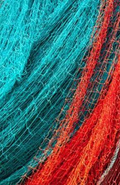 red, blue and green fishing nets are stacked together