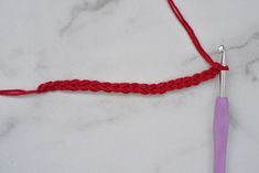 the crochet hook has been hooked up with a red thread and is ready to be knitted