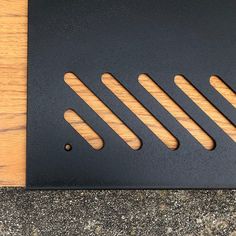 a close up of a metal grate on a wooden surface