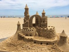 a sand castle sitting on top of a sandy beach