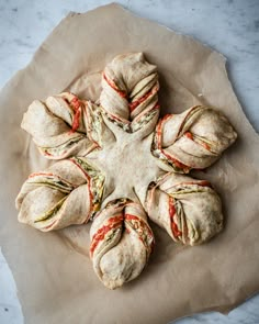 several sandwiches are arranged in the shape of a star on a piece of parchment paper