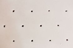 several square holes in the wall that have been made into something with black dots on them