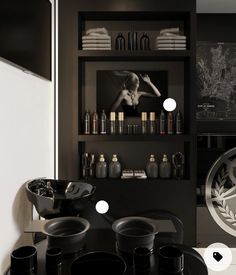 a black and white kitchen with lots of plates on the counter top in front of shelves