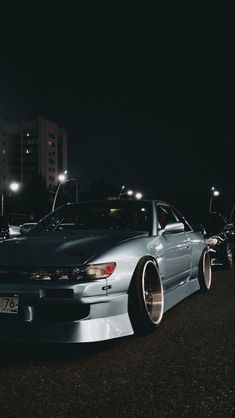 a silver car parked on the street at night