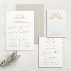 the wedding stationery is laid out on a white surface with gold foil and greenery