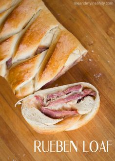 a close up of a sub sandwich on a wooden table with the words reuben loaf