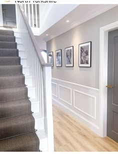 a staircase with pictures on the wall and carpeted stairs leading to another room in the house