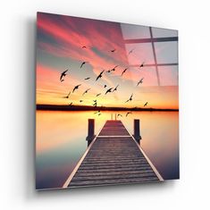 a dock with birds flying over it at sunset or dawn canvas wall art print on the wall