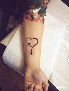 a woman's arm with an anchor and heart tattoo on her left wrist, which is in the shape of a heart