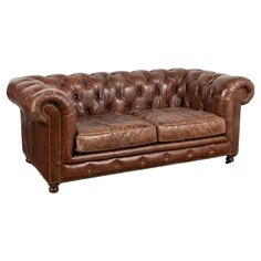 a brown leather couch sitting on top of a white floor