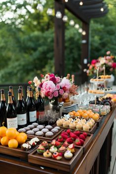 an outdoor buffet with cupcakes, oranges and desserts on it's table