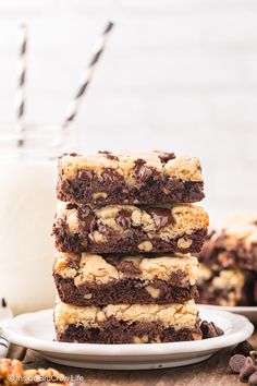 three chocolate chip cookie bars stacked on top of each other with milk in the background