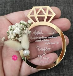 a person holding a ring with flowers in it