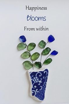 a blue and white vase with flowers in it on a card saying happiness blooms from within