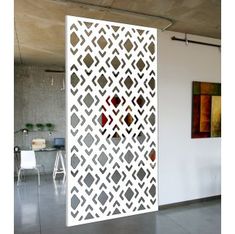 an open white door with geometric designs on the outside and inside, in front of a dining room table