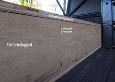 the platform support wall is made out of wood and has writing on it that says platform support