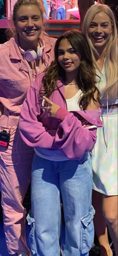 three girls in matching pink outfits posing for the camera