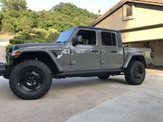 a gray jeep parked in front of a house