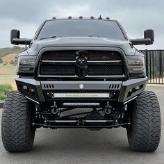 the front view of a black ram truck with large tires and big tires on it