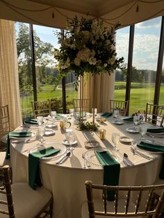 the table is set with green and white linens for an elegant wedding reception at the golf course