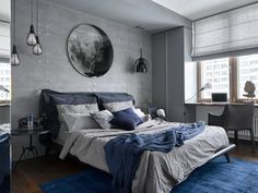 a bedroom with grey walls and blue rugs on the floor, along with a large bed