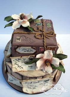 a cake that is decorated with luggage and flowers