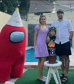 a family poses for a photo in front of an inflatable red monster with a birthday cake