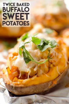 a close up of a baked potato with cheese and parsley on the top, sitting on foil