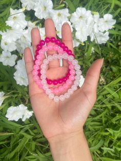 This 3 piece beaded bracelet set contains 8mm glass beads and includes hot pink, light pink and cloudy white. These bracelets have a shiny glossy look, have a cooling feel and are light weight. With a glossy, smooth look the bracelets look beautiful as you move through the day. The color of the product may look slightly different due to lighting. The hot pink is one our shops favorites as it adds a bold pretty color to your wrist. The light pink adds a soft shade of pink to contrast and compliment the hot pink. The white bracelet makes a clean classy look as it fit well to even out the amount of color on your wrist. Whether they're wore stacked or separate they're the perfect bracelets to add to your jewelry collection.   Made with strong, durable elastic string that allows the bracelet to Pink Hand-strung Friendship Bracelets With Round Beads, Pink Round Beads Crystal Bracelet For Spiritual, Pink Round Beads Crystal Bracelet Spiritual, Pink Round Spiritual Beaded Bracelets, Pink Rose Quartz Stretch Bracelet With 8mm Beads, Pink Spiritual Crystal Bracelet With Round Beads, Pink Spiritual Stretch Bracelet With Round Beads, Beaded Rose Quartz Bracelets With Round Beads, Spiritual Pink Stretch Bracelet With Round Beads