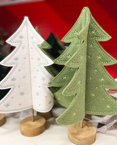 three small christmas trees sitting on wooden stands