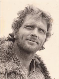 black and white photograph of a man in fur coat looking off to the side with eyes wide open