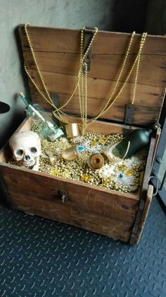 an open wooden chest filled with lots of gold and other items on top of a blue floor