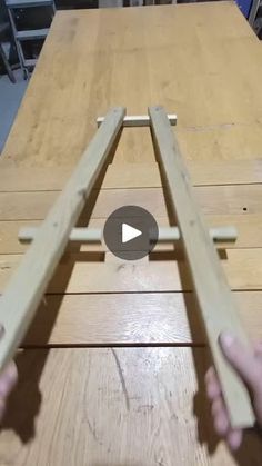 two hands are holding wooden planks on top of a table