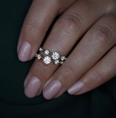 a woman's hand with three diamond rings on top of her fingers and the middle finger