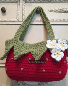 a crocheted strawberries purse hanging on a door