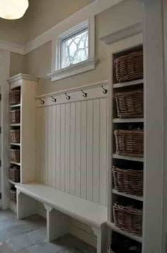 a white bench sitting in the middle of a room filled with lots of shelves and baskets