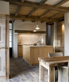 a wooden table sitting in the middle of a kitchen