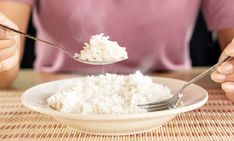 a person eating rice with a spoon and fork