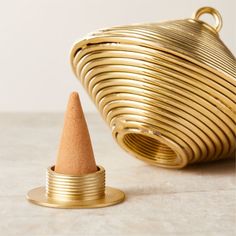 a small gold colored cone next to a golden metal container