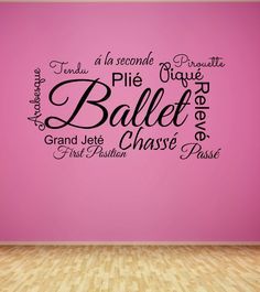 a pink wall with the words ballet on it in black and white, against a wooden floor