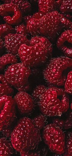 red raspberries are piled together in a pile