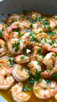 a pan filled with shrimp and garnished in sauce