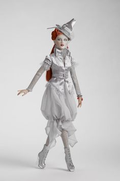 a doll is dressed in white and silver