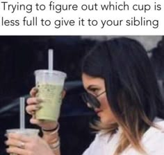 a woman holding up a drink in front of her face with the caption trying to figure out which cup is less full to give it to your sibling