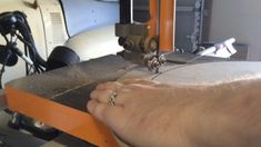 a person is using a machine to make something out of wood and metal with their foot