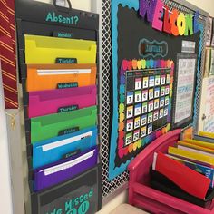 colorful file folders are lined up on the wall in front of a bulletin board