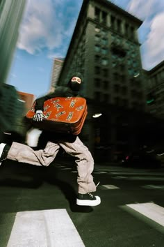 a man is running across the street with a suitcase on his back and feet in the air