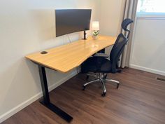 an office desk with a computer monitor on top of it and a chair next to it