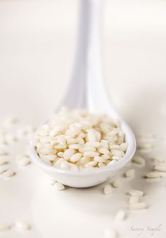 a spoon filled with white rice on top of a table