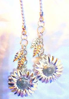 two sunflowers are attached to silver chains